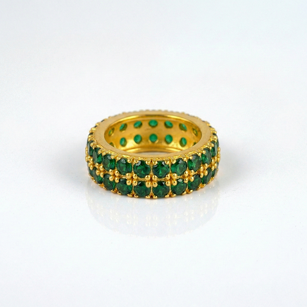 Gold ring with green gemstones on a white background