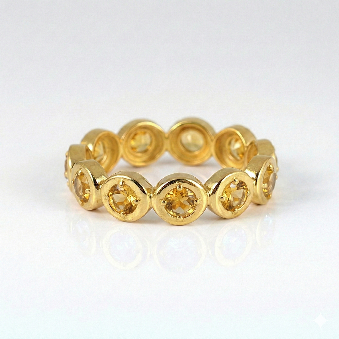 Gold ring with circular gemstones on a white background