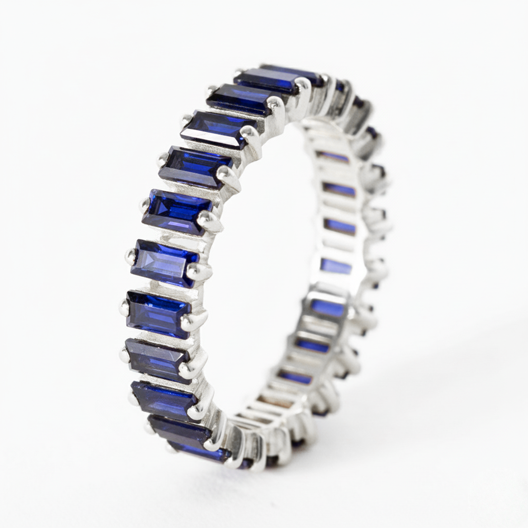 Silver ring with blue gemstones on a white background