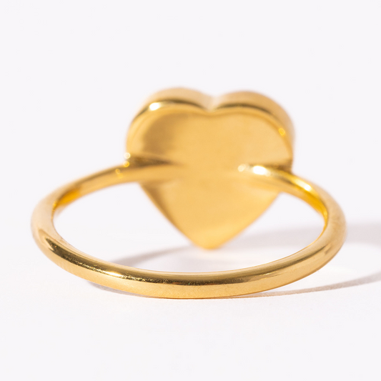 Gold heart-shaped ring on a white background