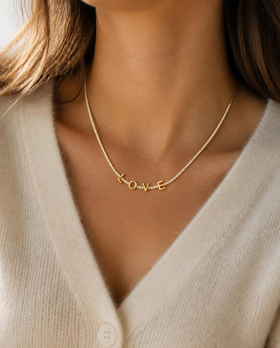 Roma LOVE necklace worn with a cream cardigan