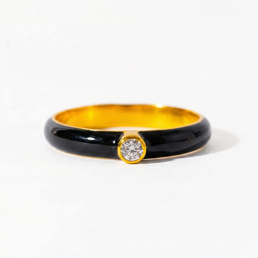 Gold and black ring with a diamond on a white background