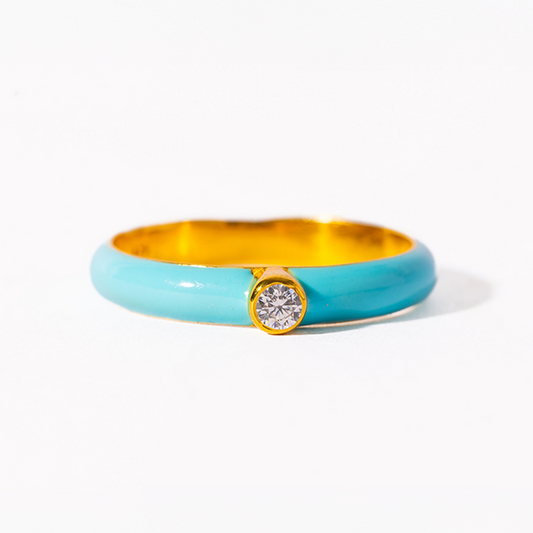 Turquoise ring with gold band and diamond on a white background