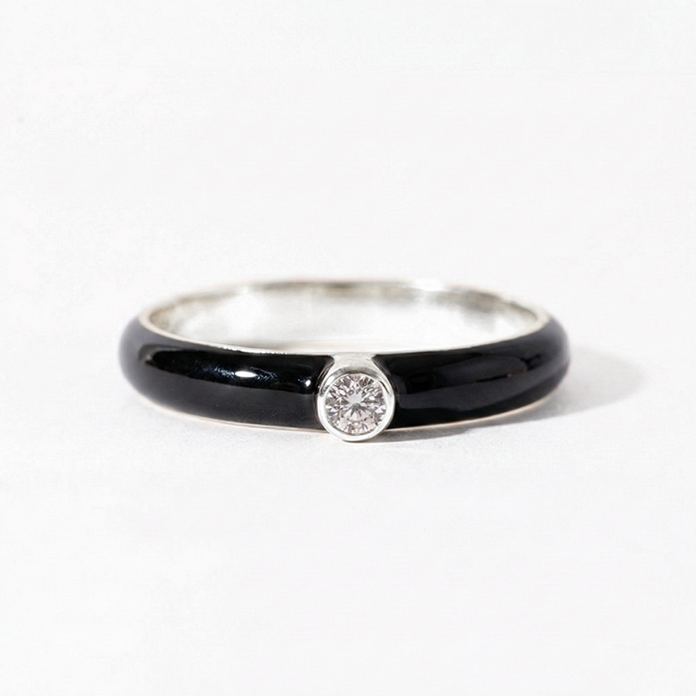 Ring with black band and diamond on a white background
