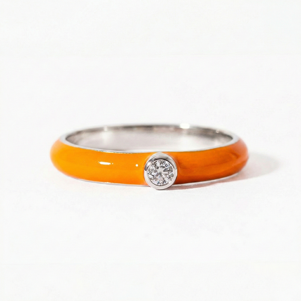 Orange ring with a silver band and central gemstone on a white background