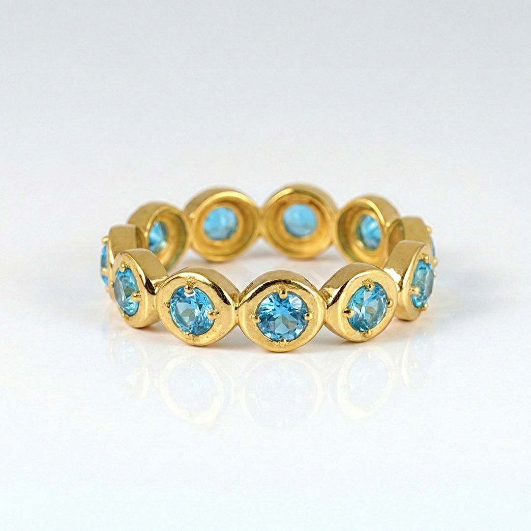 Gold ring with blue gemstones on a white background