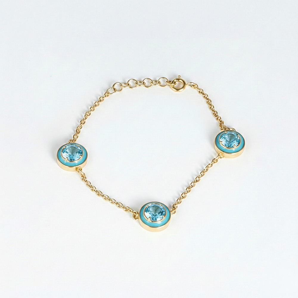 Gold bracelet with turquoise gemstones on a white background