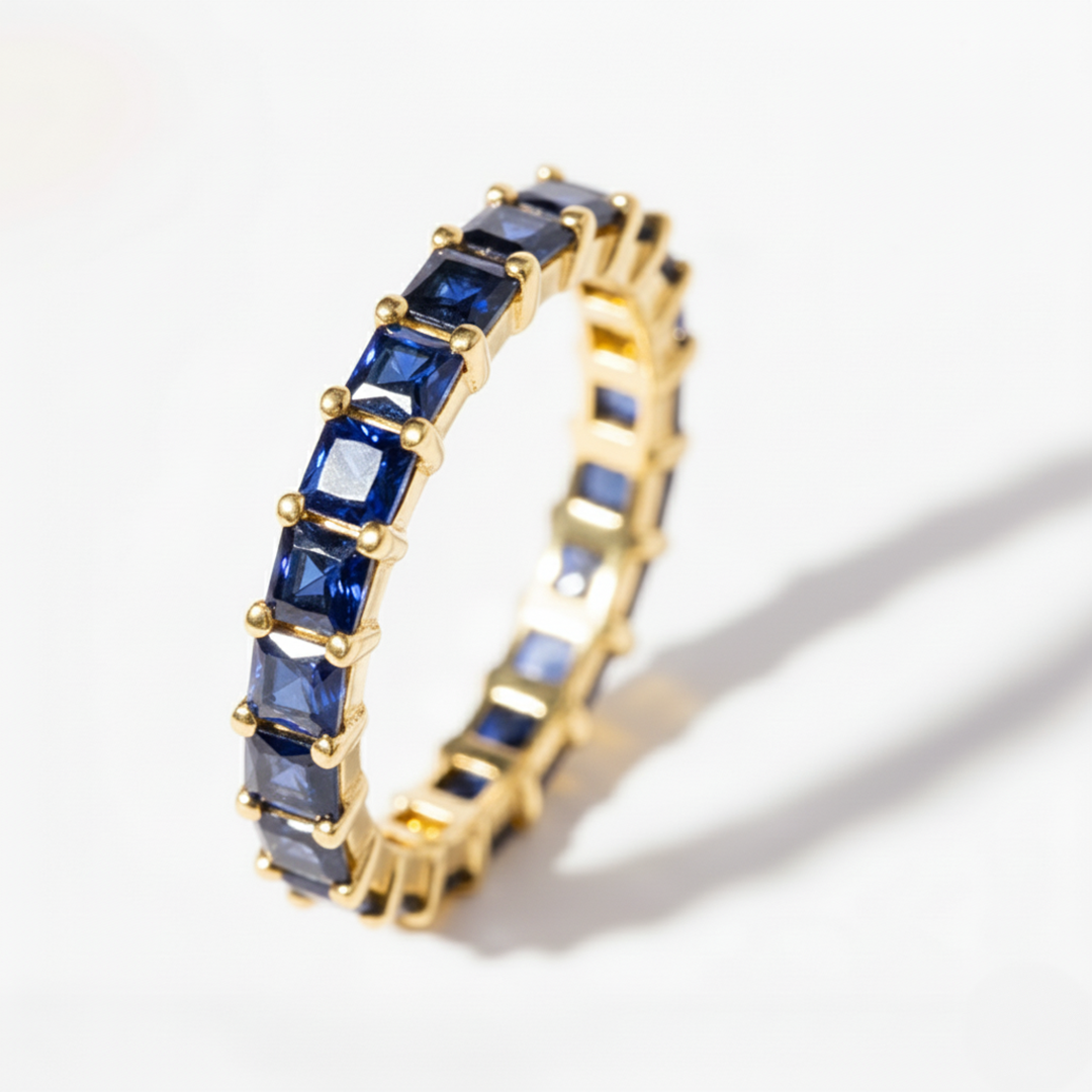 Gold ring with blue gemstones on a white background