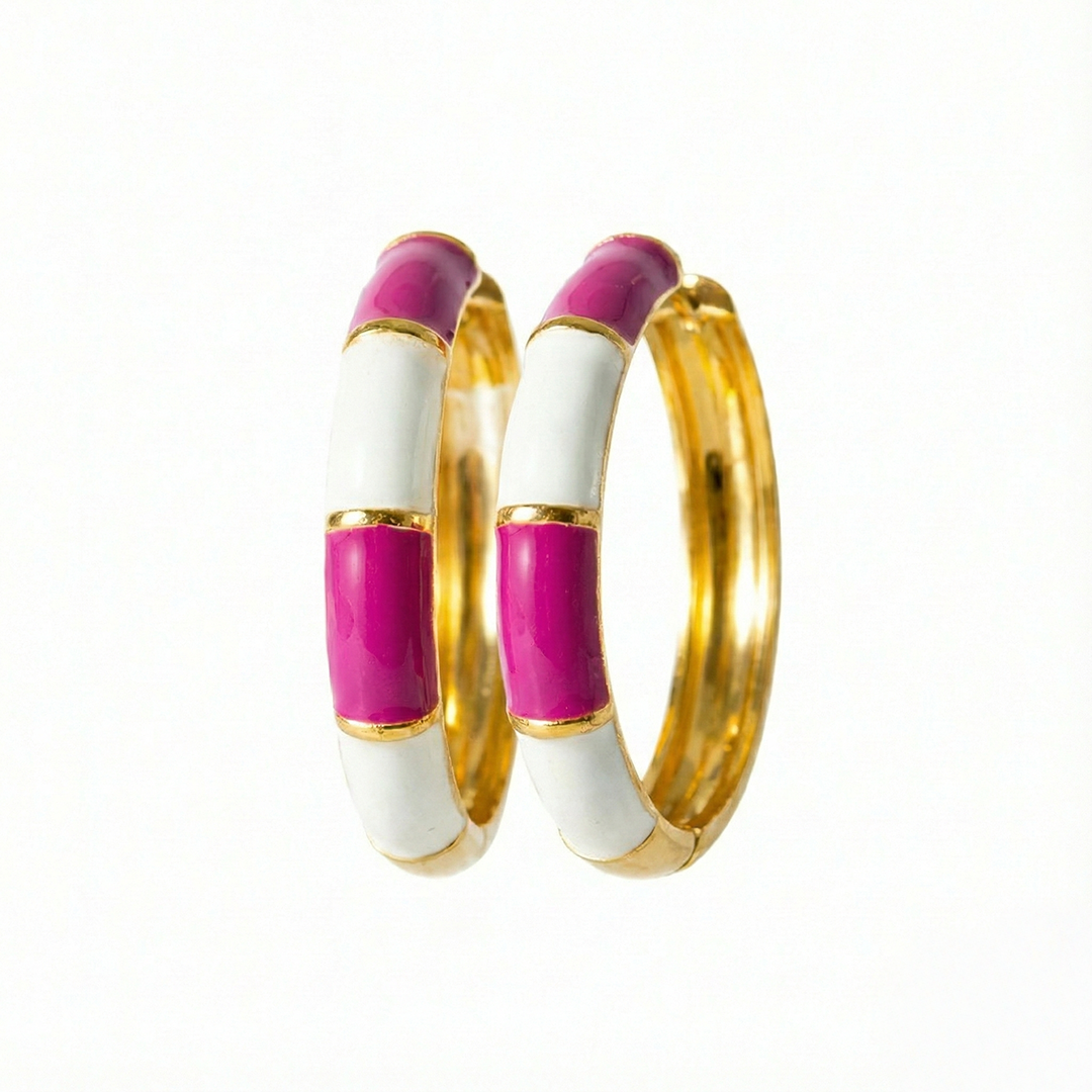 Two hoop earrings with gold, white, and pink color scheme on a white background
