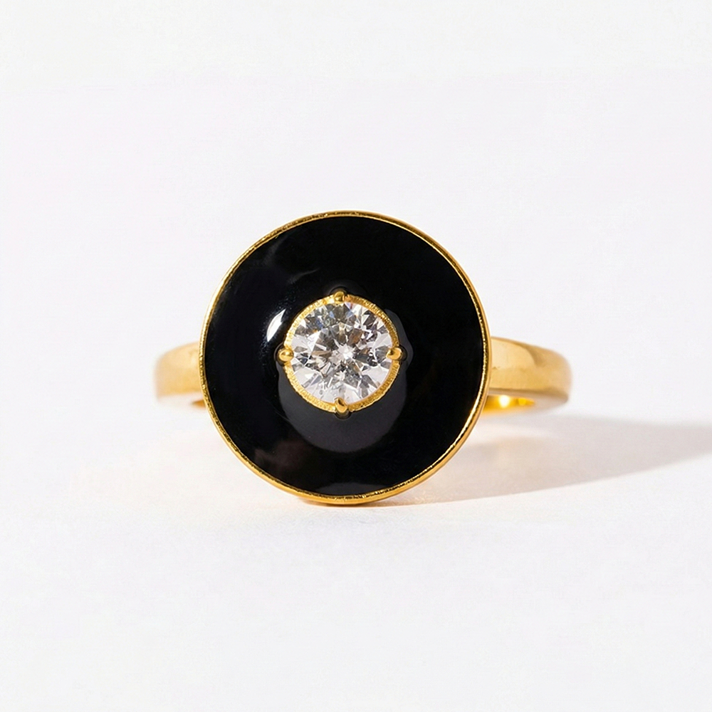 Gold ring with a black circular stone and central diamond on a white background