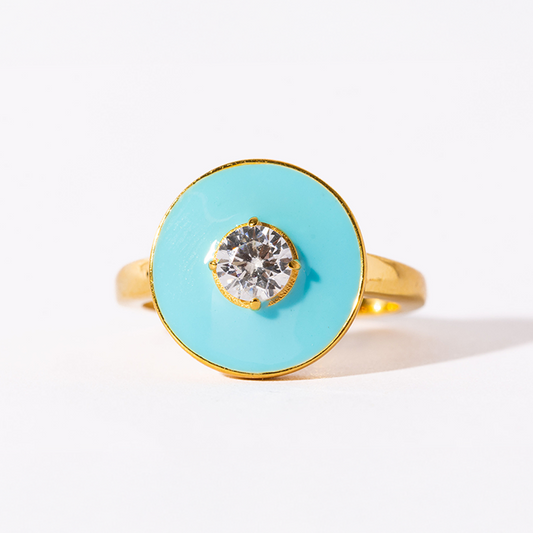 Ring with turquoise circular stone and gold band on a white background