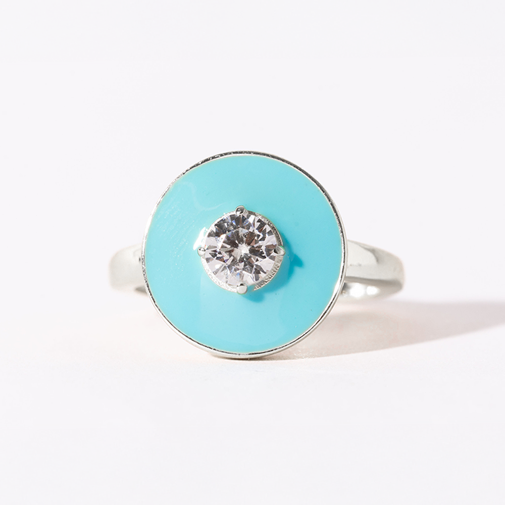 Ring with a turquoise circular stone and silver band on a white background