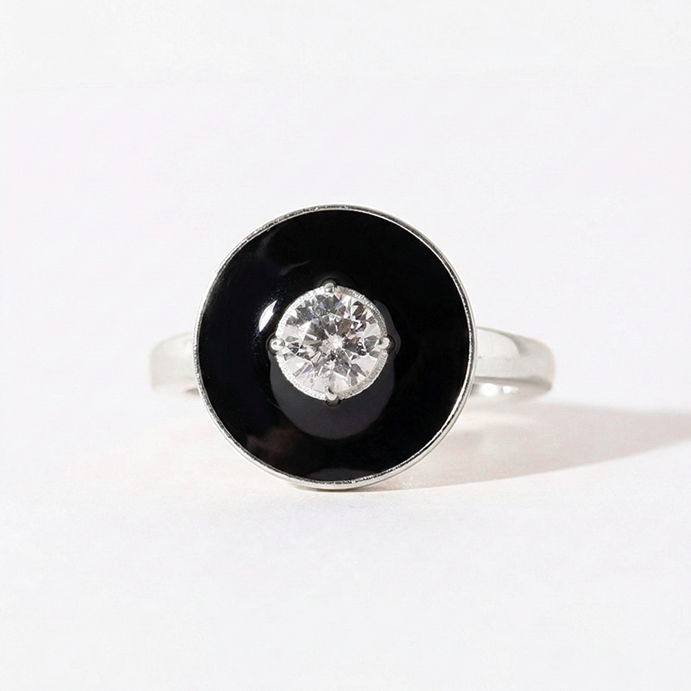 Ring with black circular stone and silver center on a white background