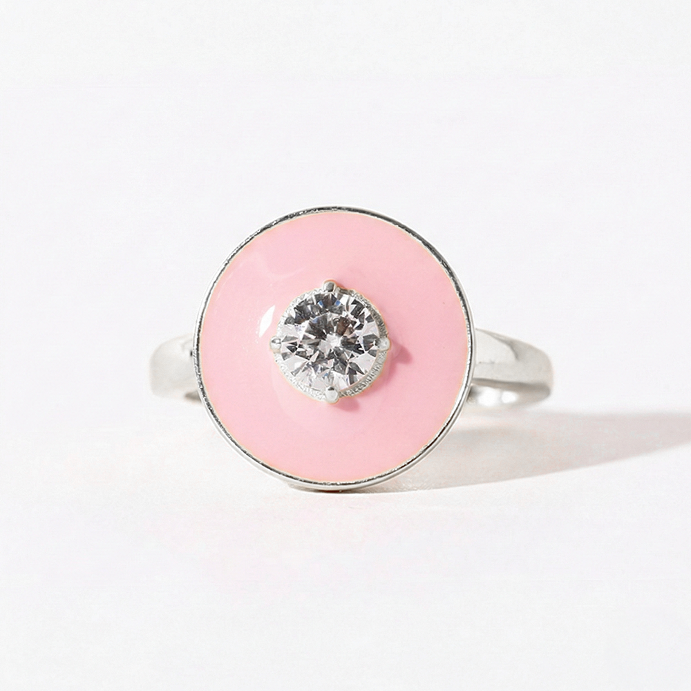 Ring with pink circular stone and silver band on a light gray background