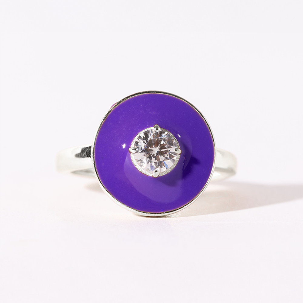 Ring with a purple circular stone and clear gemstone on a white background