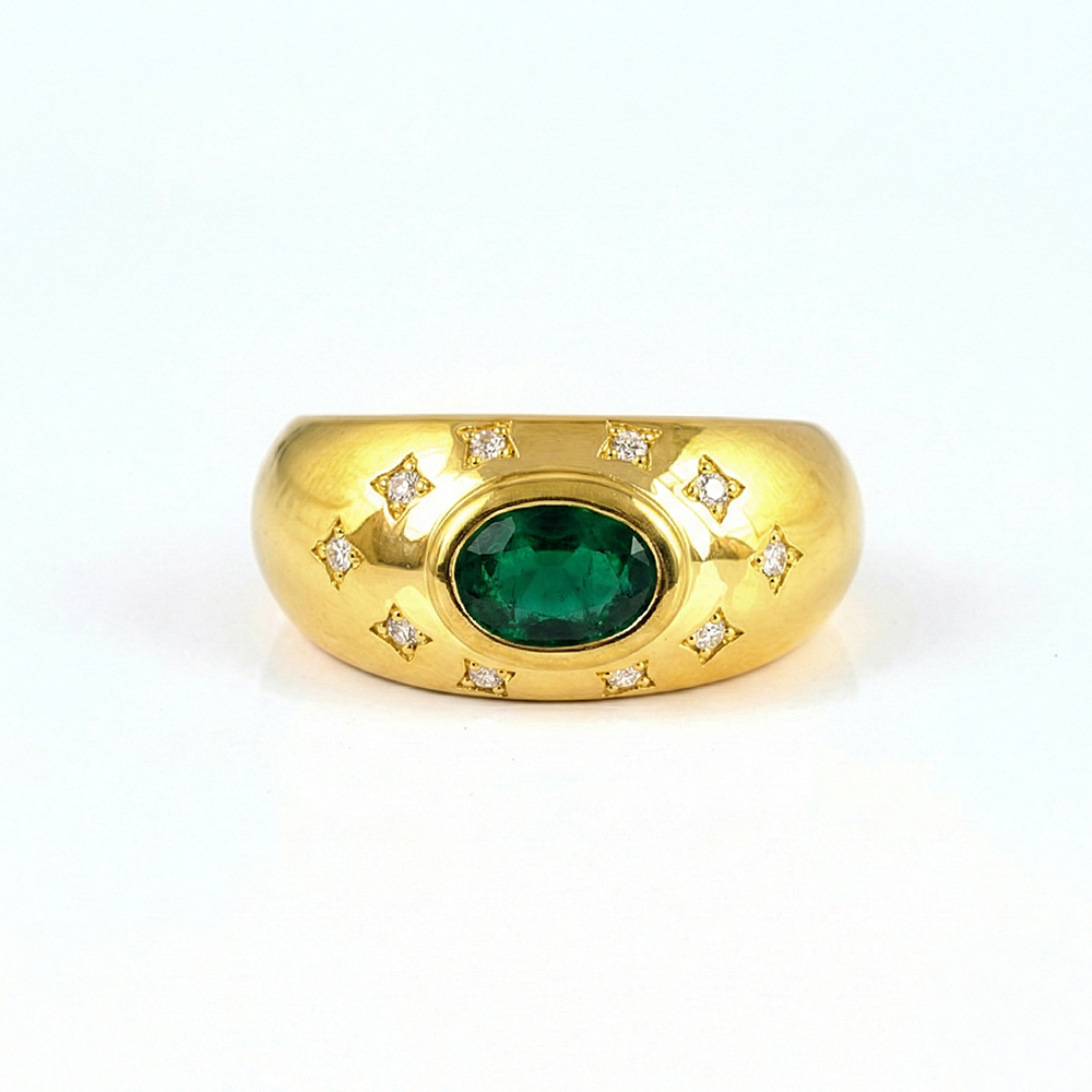 Gold ring with a green gemstone and diamond accents on a white background