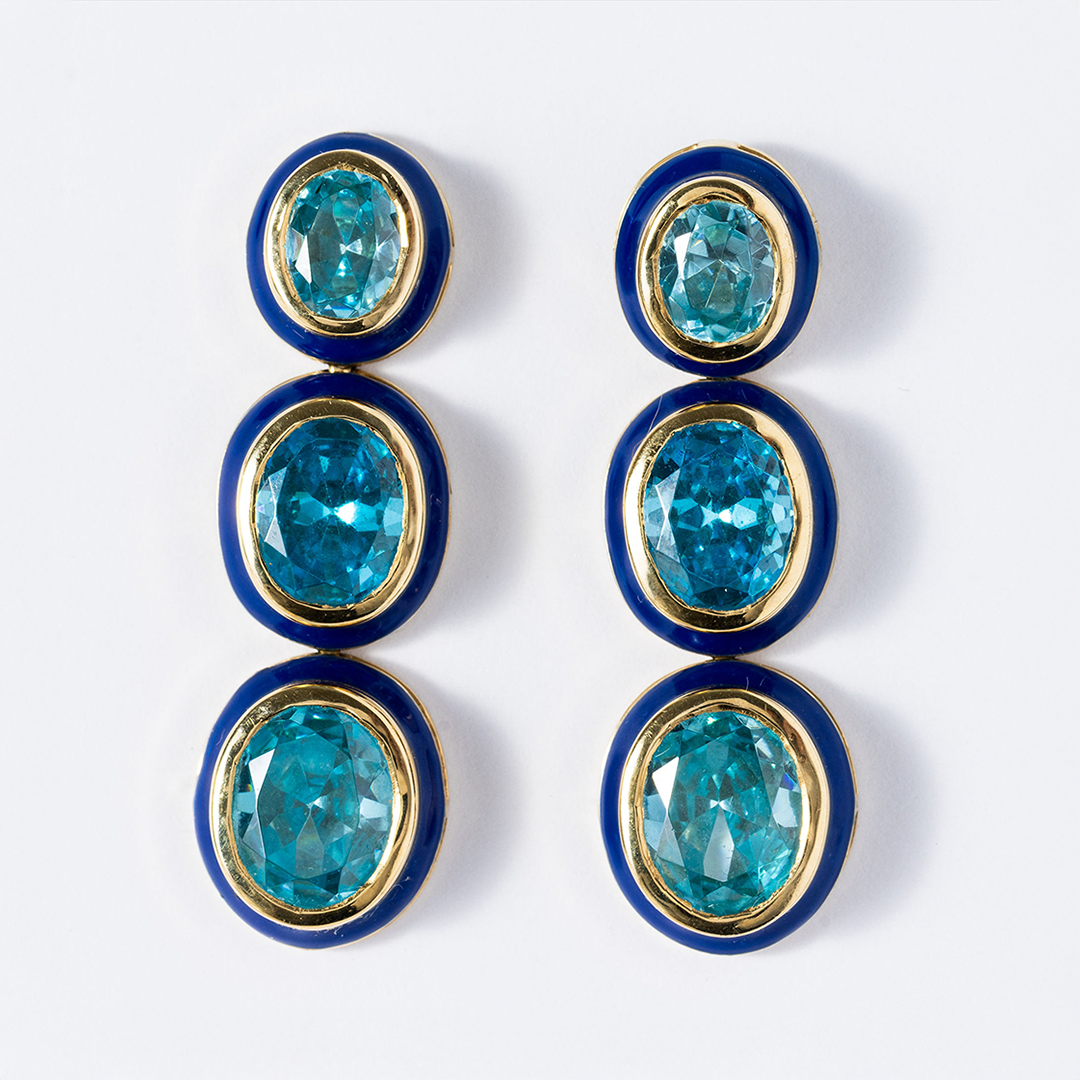 Pair of earrings with blue gemstones and gold accents on a white background