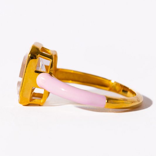 Gold ring with a pink accent on a white background