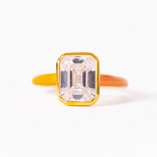 Gold ring with a large rectangular diamond on a white background