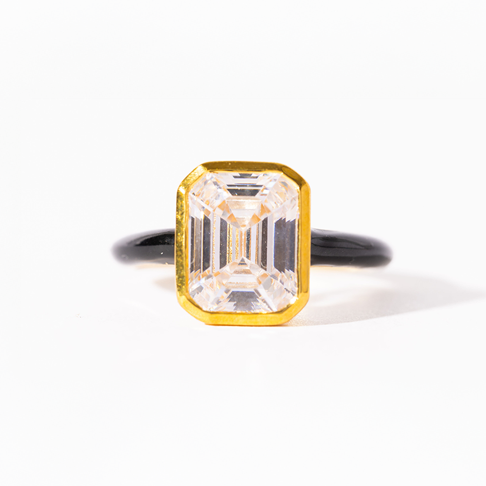 Ring with a large rectangular diamond in a gold setting on a white background