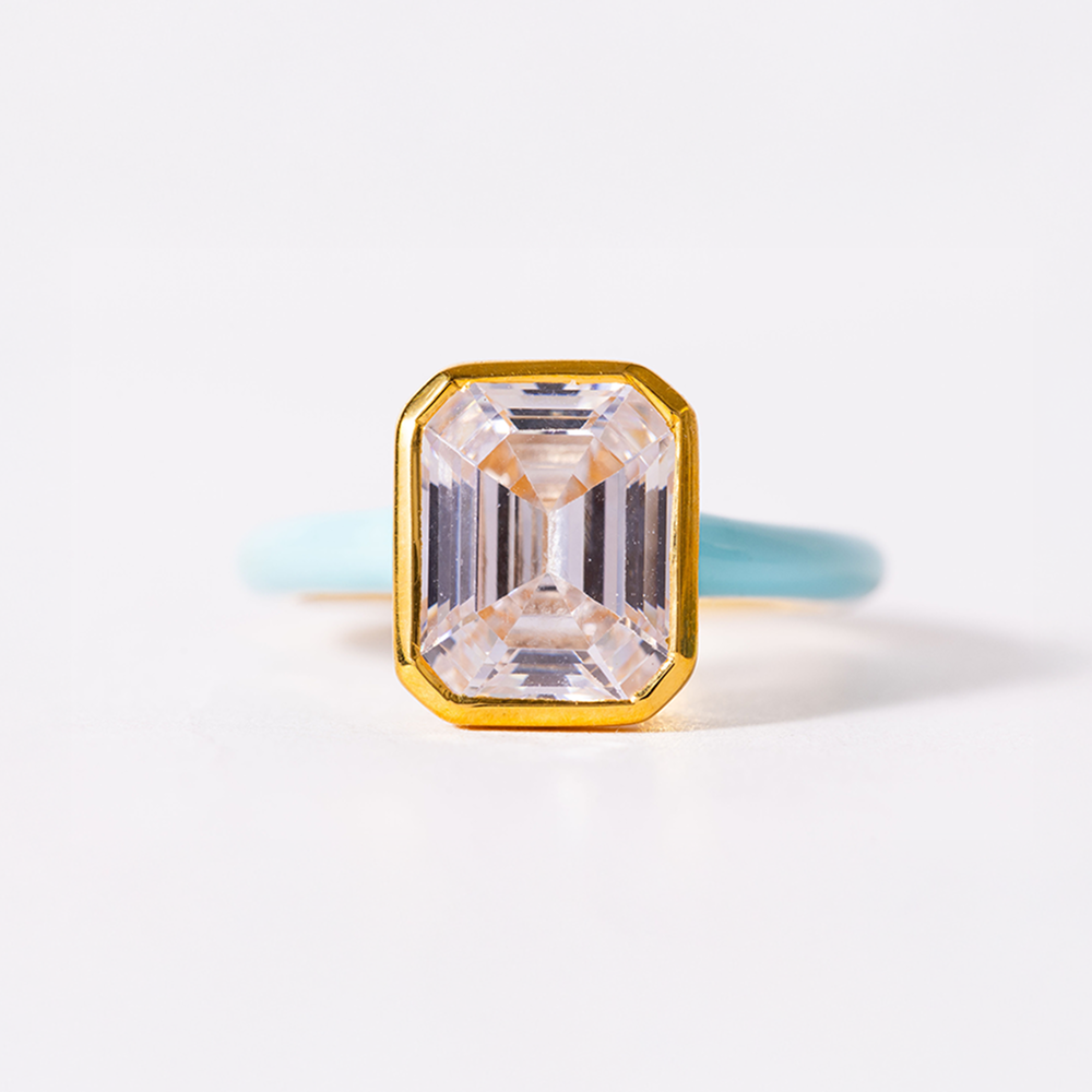 Gold ring with a large rectangular gemstone on a light background