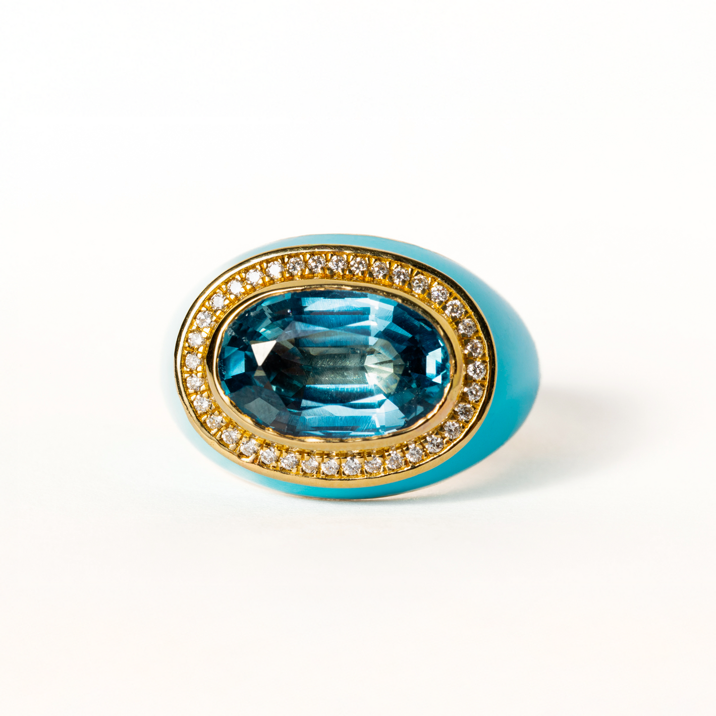 Jewelry ring with blue gemstone and gold band on a white background