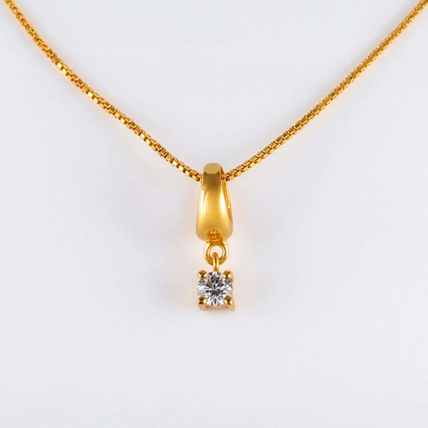 Gold necklace with a diamond pendant on a white background