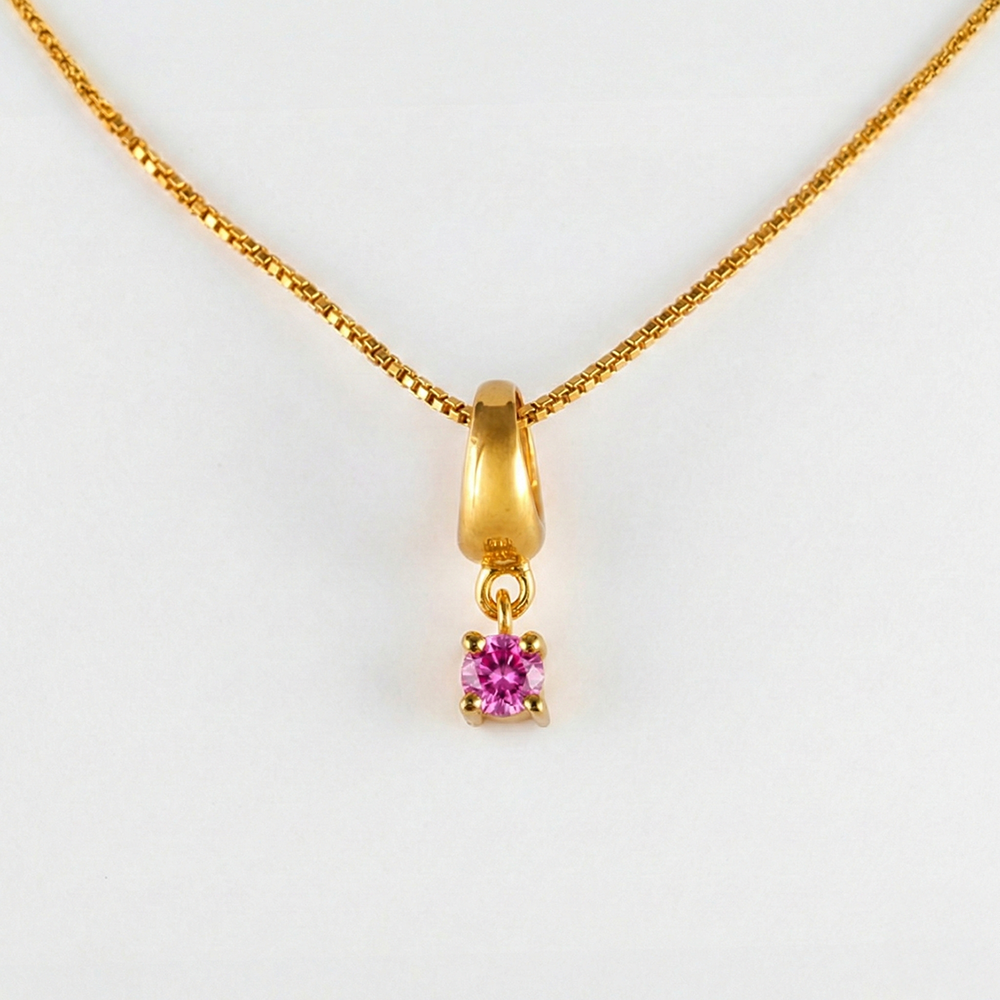Gold necklace with a pink gemstone pendant on a white background