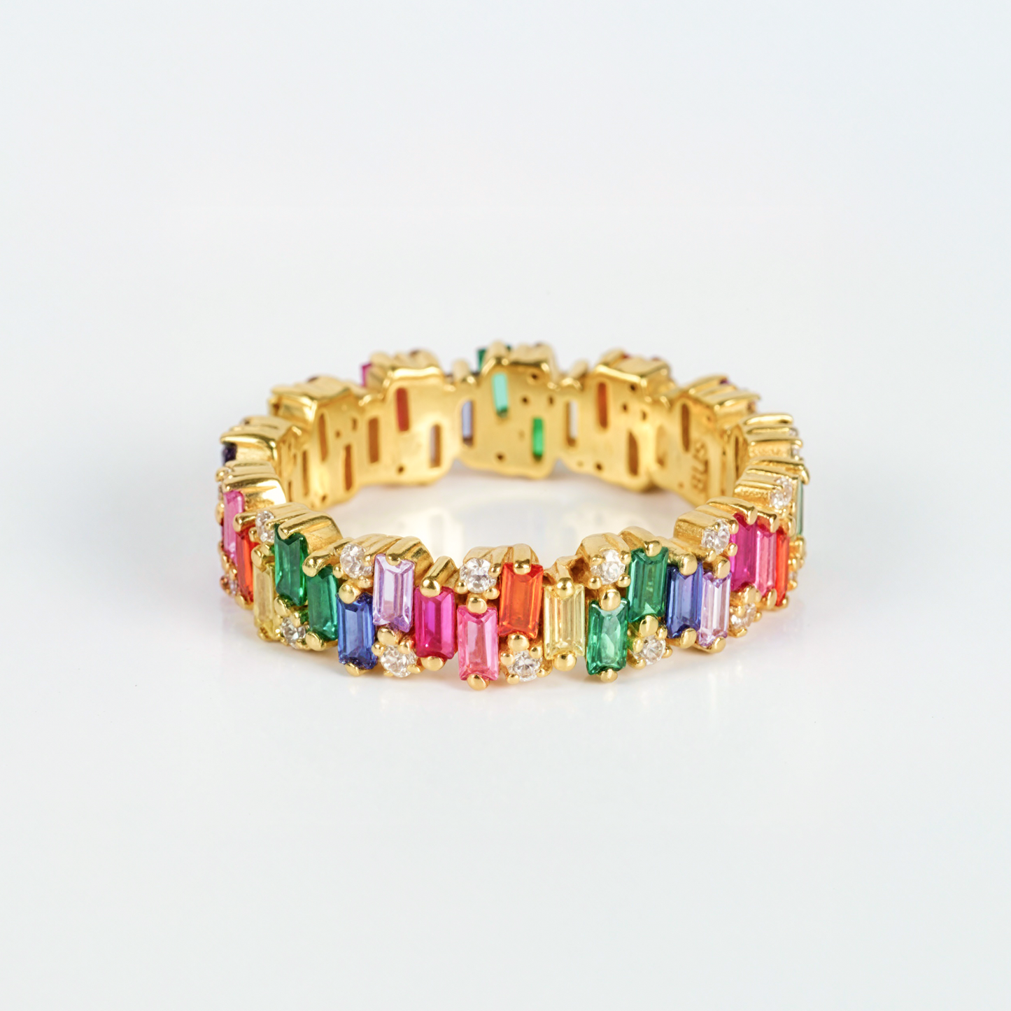 Gold bracelet with colorful gemstones on a light gray background