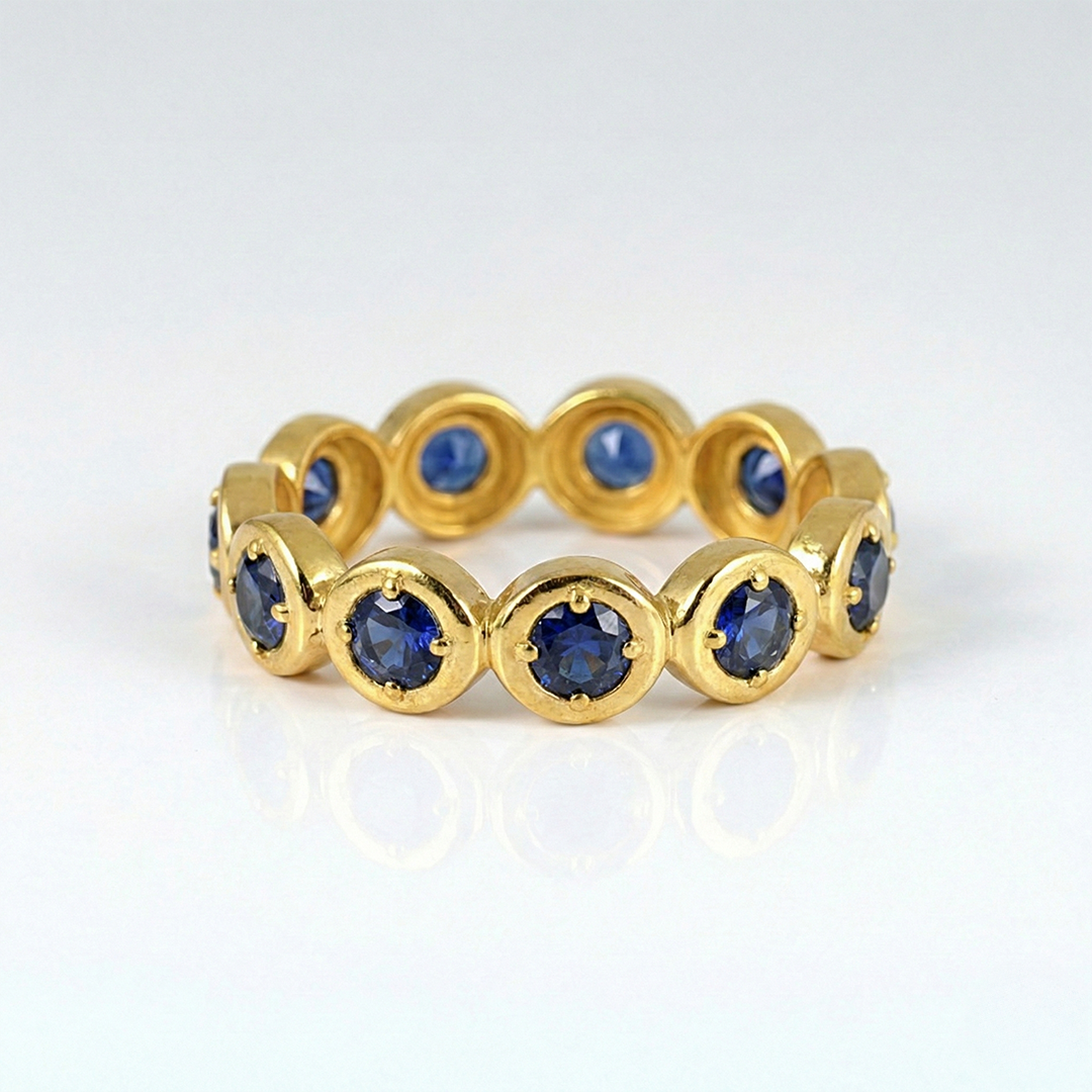Gold ring with blue gemstones on a white background