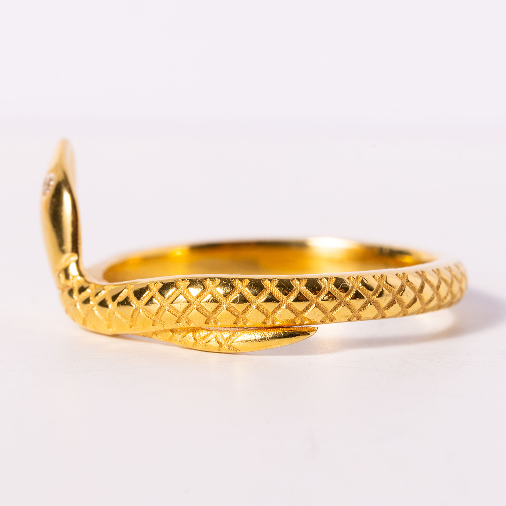 Gold bracelet with textured design on a white background