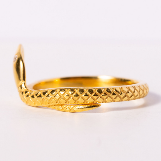 Gold bracelet with textured design on a white background