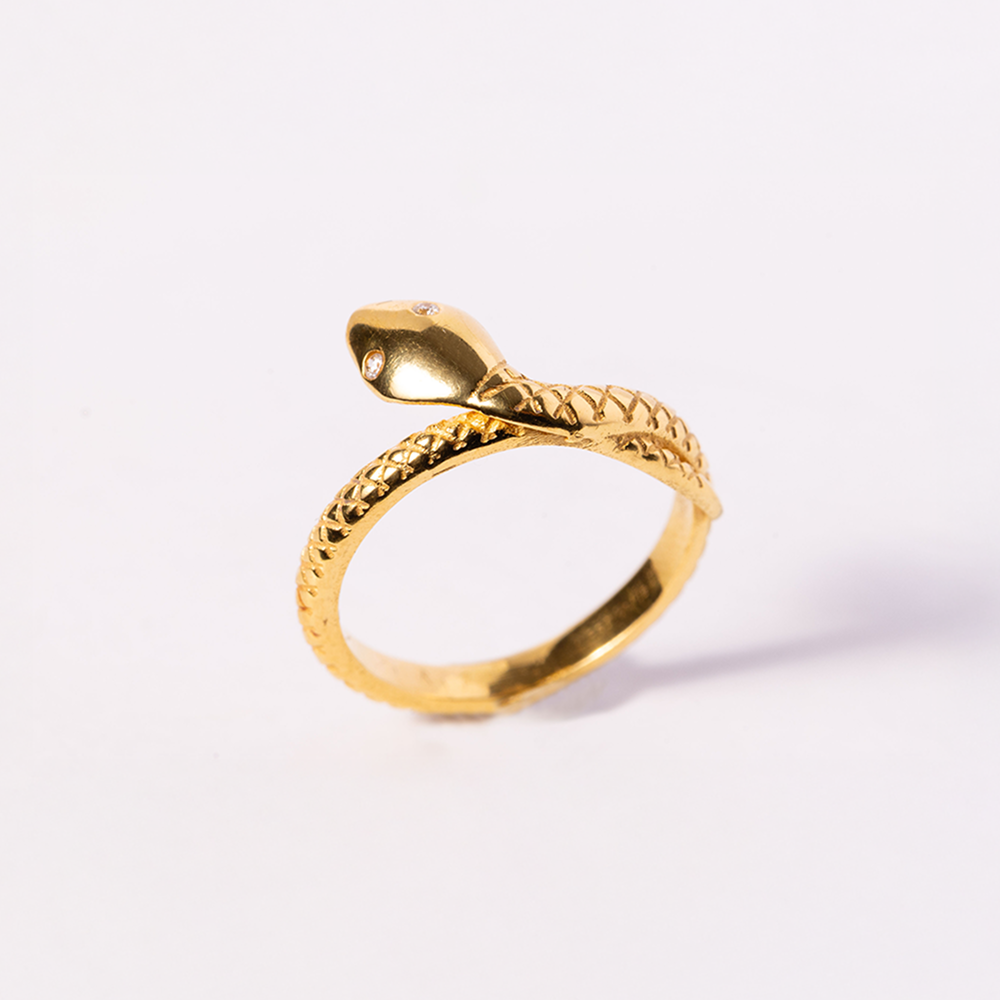 Gold snake-shaped ring on a white background