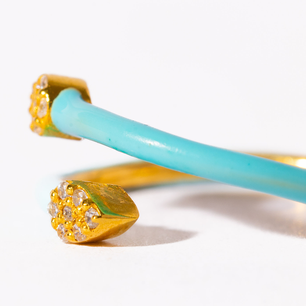 Gold and turquoise bangles on a white background