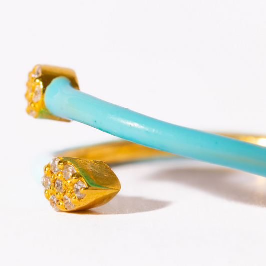 Gold and turquoise bangles on a white background