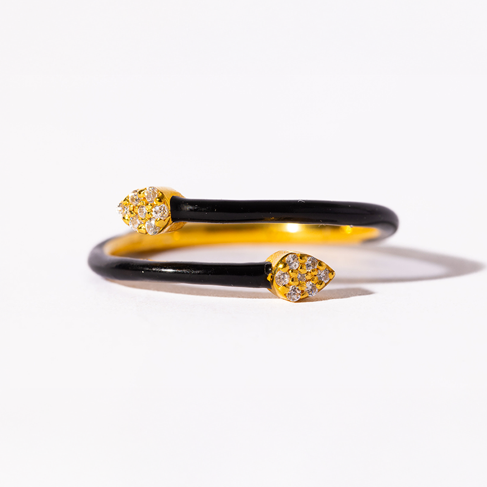 Two black and gold bangles with diamond accents on a white background