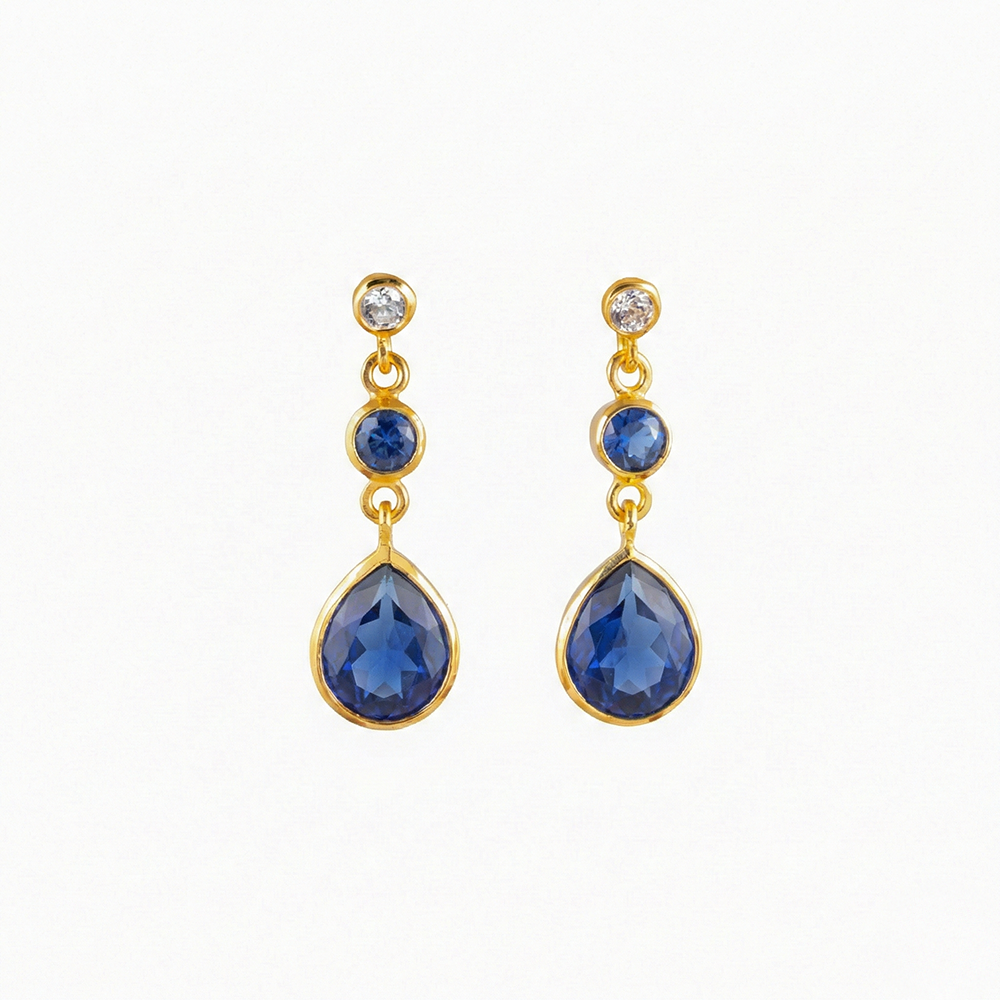 Gold earrings with blue gemstones on a white background