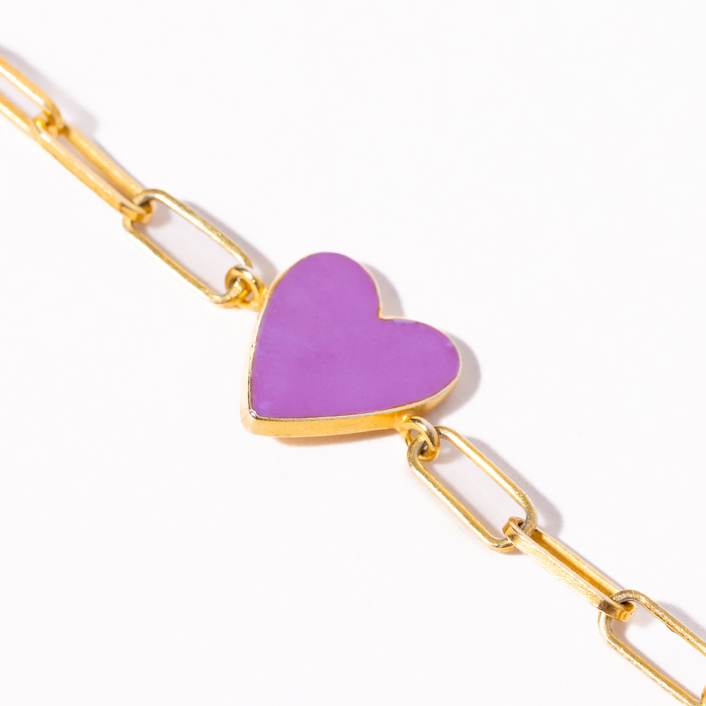 Gold chain bracelet with a purple heart charm on a white background