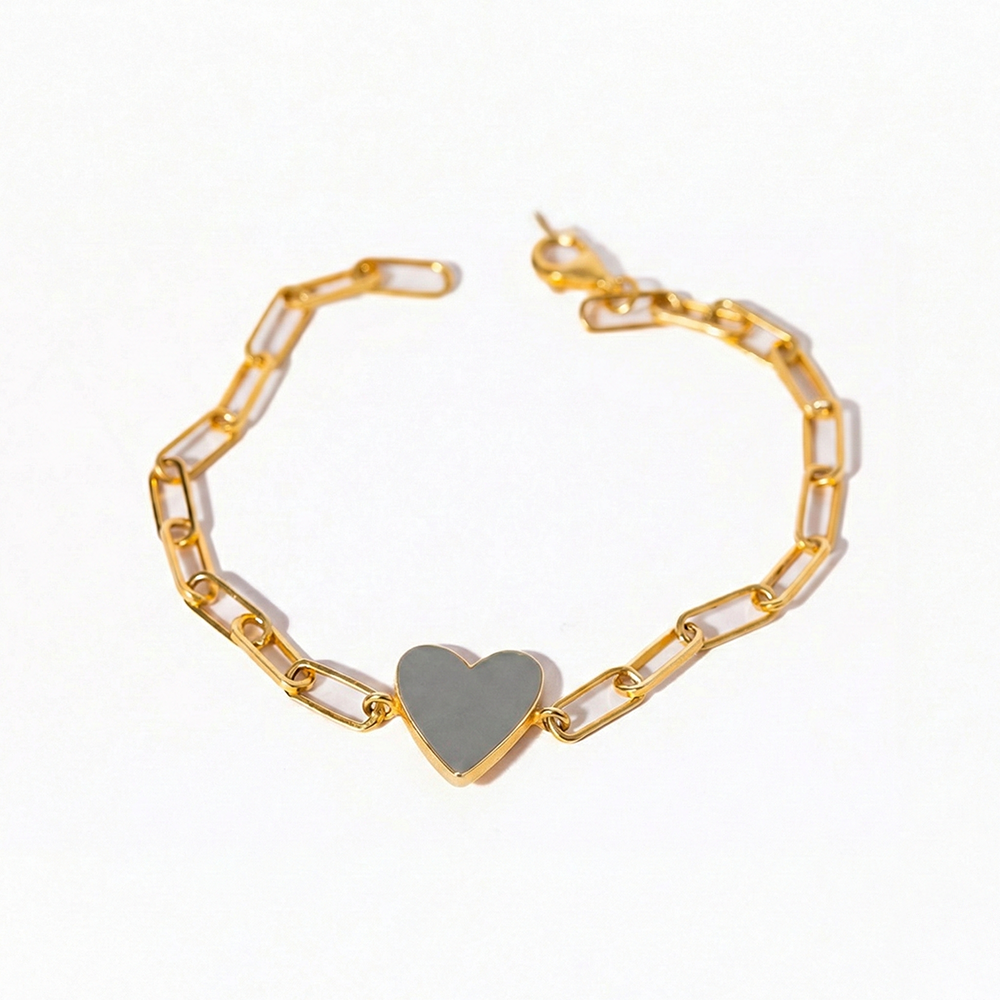 Gold bracelet with a heart-shaped charm on a white background