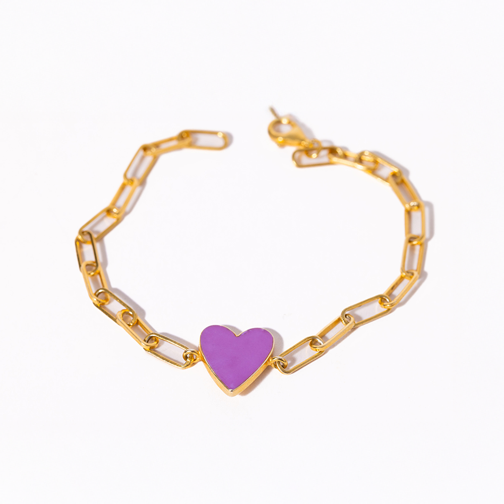Gold chain bracelet with a purple heart charm on a white background