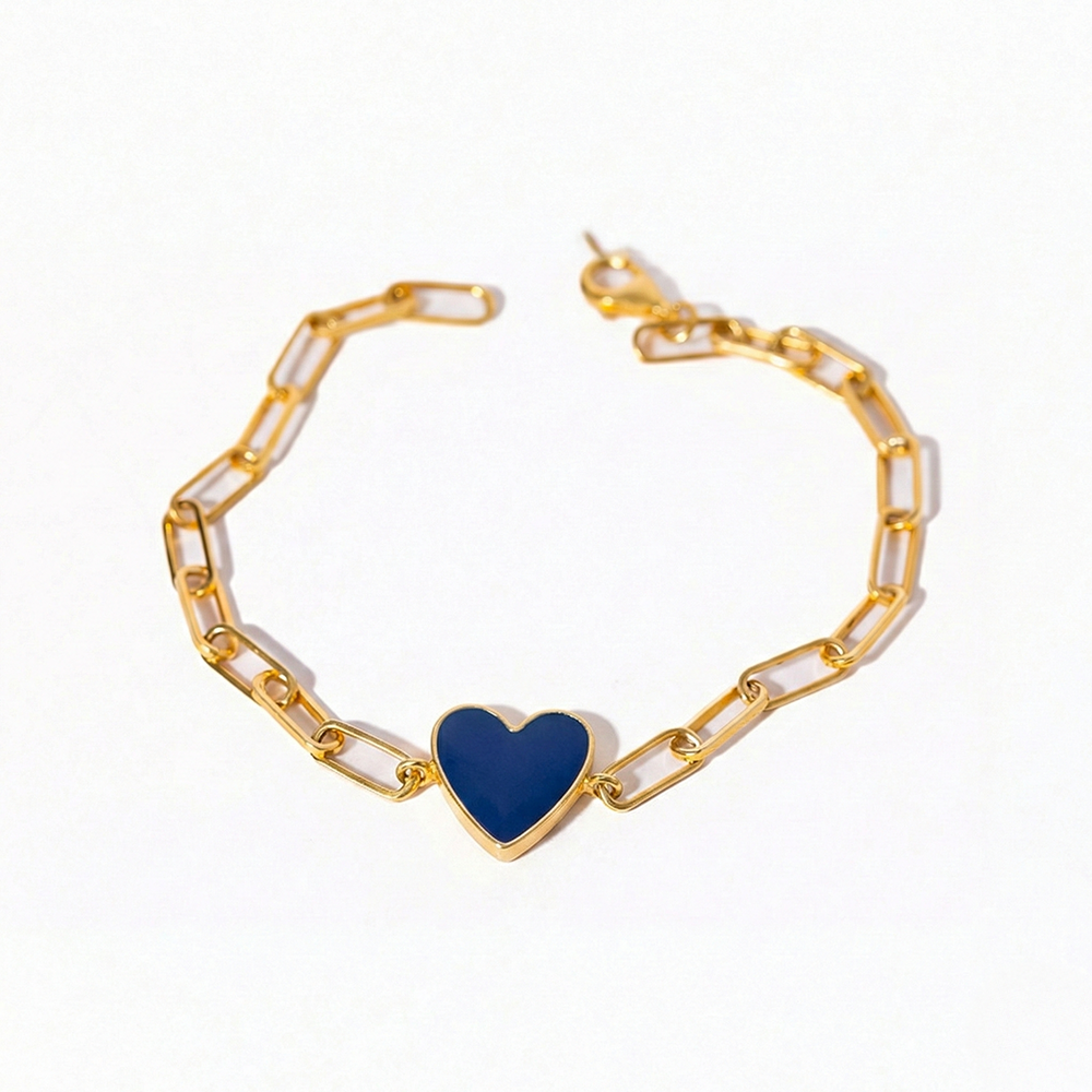 Gold bracelet with a blue heart charm on a white background