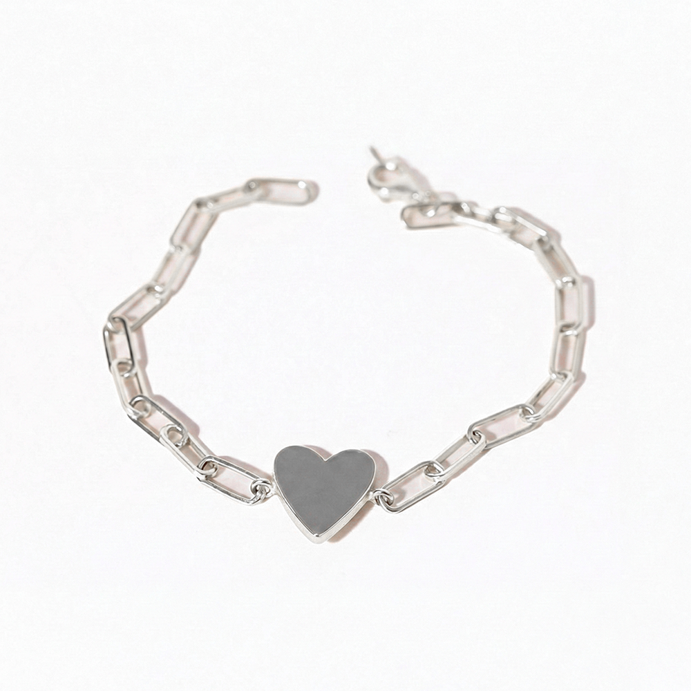 Silver bracelet with a heart-shaped charm on a white background