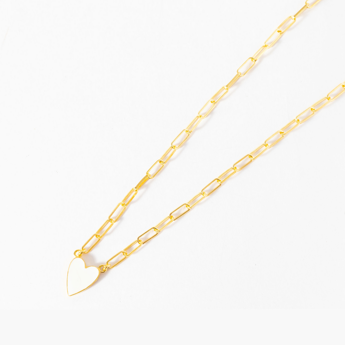 Gold chain necklace with a heart-shaped clasp on a white background
