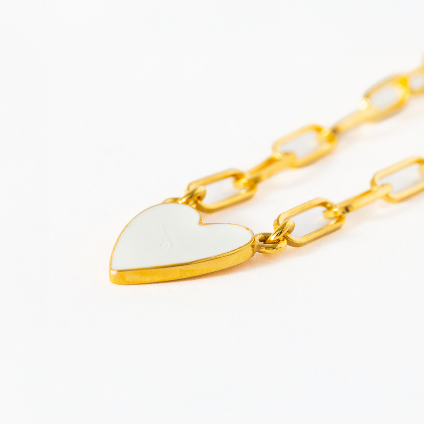 Gold chain necklace with a heart-shaped pendant on a white background