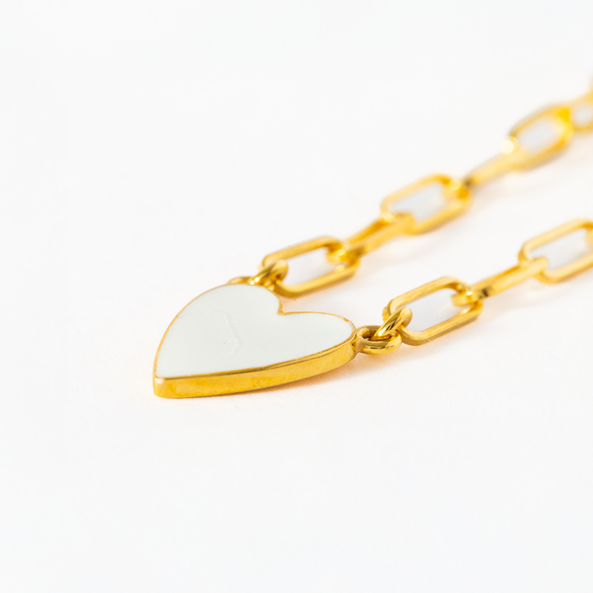 Gold chain necklace with a heart-shaped pendant on a white background