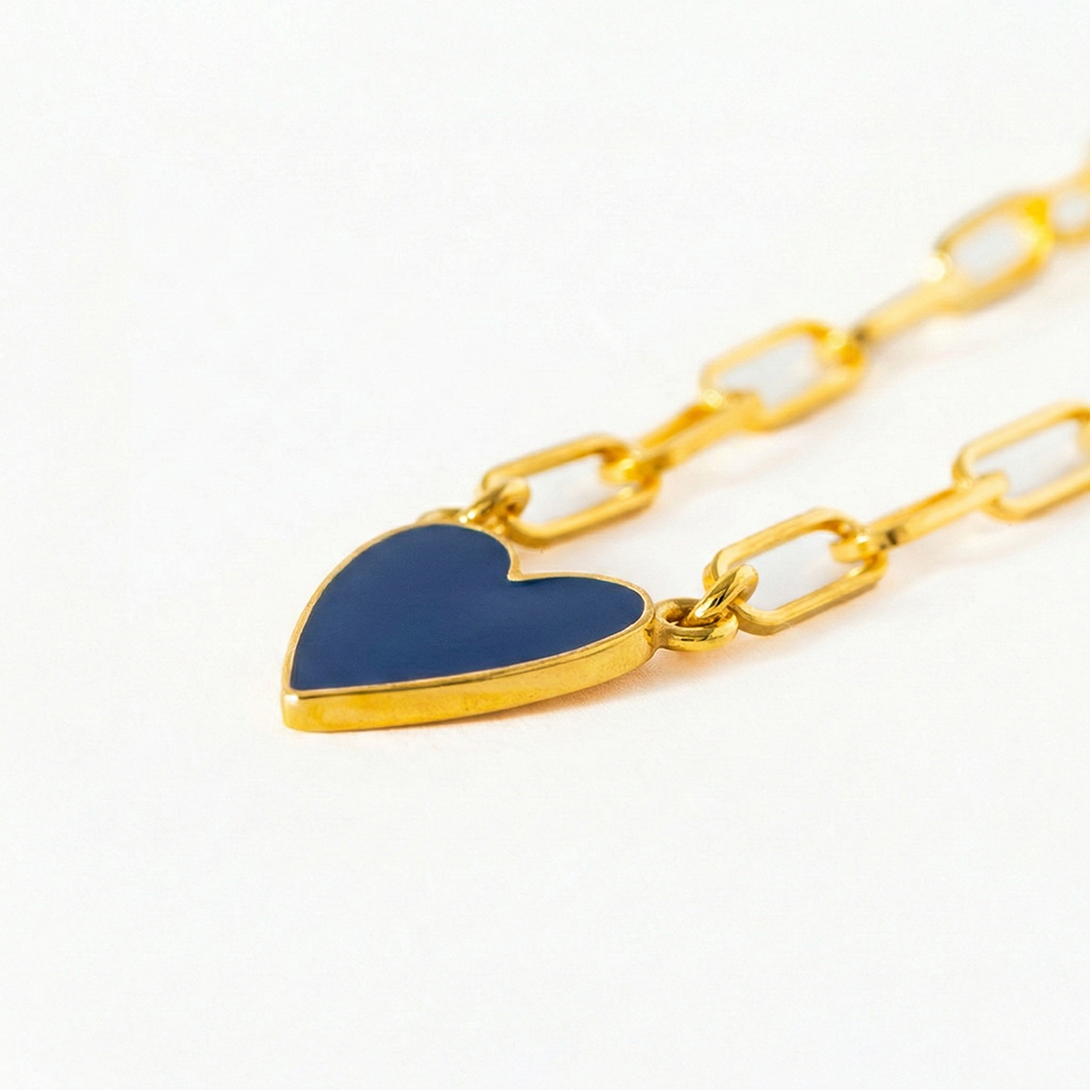Gold chain bracelet with a blue heart charm on a white background